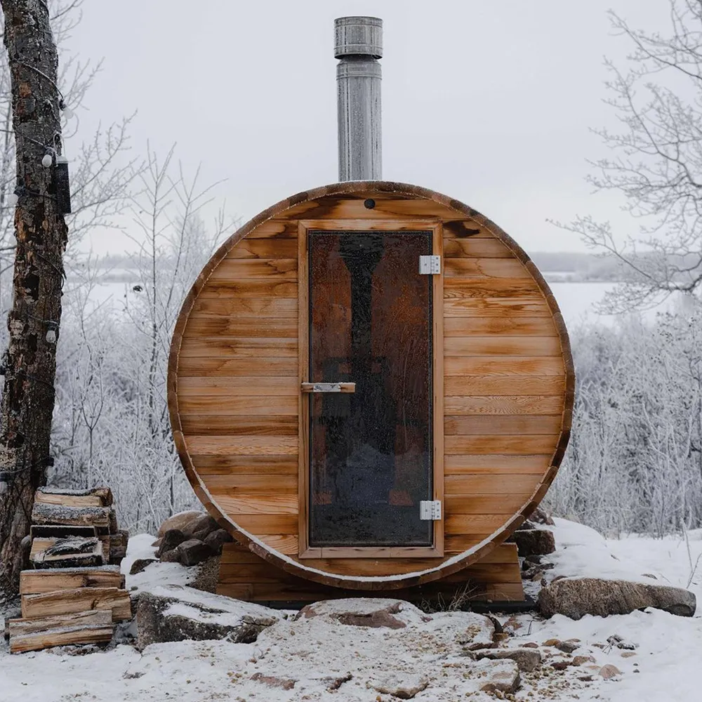 front view of ignis dome outdoor dry sauna during the winter with snow on the ground and trees