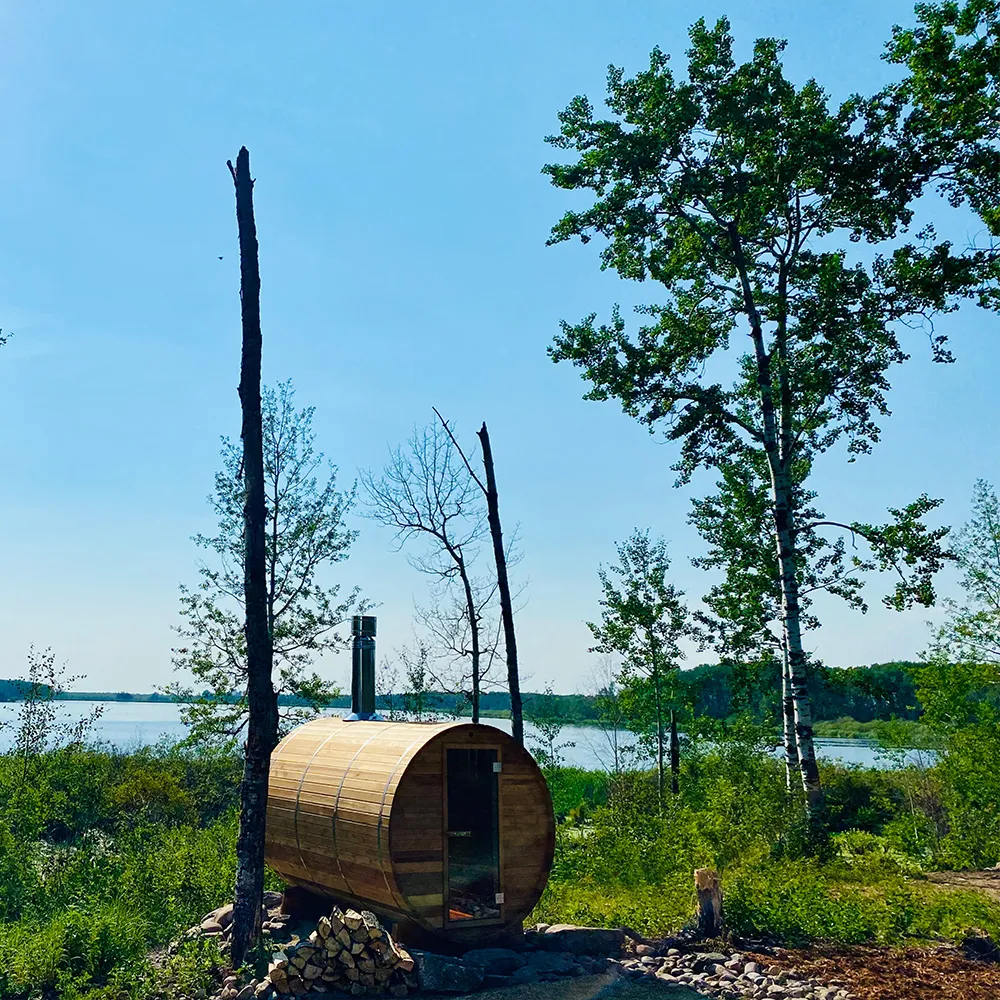 Outdoor sauna with lake and forest in the background during the summer
